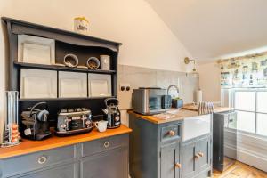 a kitchen with gray cabinets and a counter with a microwave at 1 Bed in Elstronwick oc-e42580 in Burton Pidsea