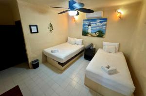 a room with two beds and a ceiling fan at Chuk-Kay by ÓOL Hotels in Holbox Island