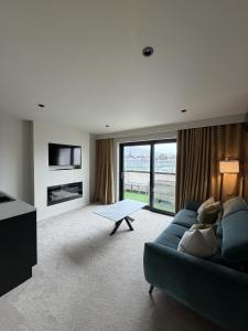 a living room with a blue couch and a television at House 15 in Kenmare