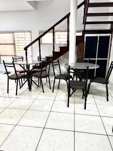 a room with tables and chairs and a staircase at HOTEL ITAPUÃ vg in Várzea Grande