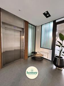 an office lobby with a glass door and a potted plant at HOMEY Departamentos in Mar del Plata