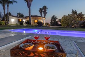 a table with wine glasses and a tray of food at Villa Cassandra in Alliste