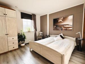 a bedroom with a bed and a painting on the wall at Ferienhof-Wohler-Wohnung-5 in Bojendorf