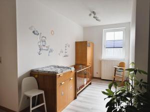 a baby room with a crib and a cabinet at Ferienhof-Wohler-Wohnung-5 in Bojendorf