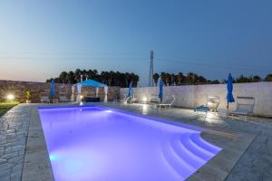a swimming pool with purple lighting in a backyard at night at Villa Cassandra in Alliste
