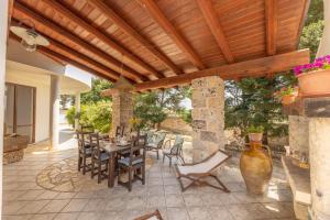 a patio with a wooden pergola and a table and chairs at Villa Cassandra in Alliste +29 photos