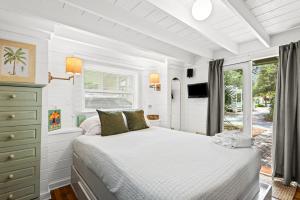 a white bedroom with a bed and a window at Margarita Days in Seagrove Beach