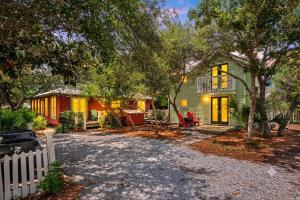 a home with a white fence and a yard at Margarita Days in Seagrove Beach
