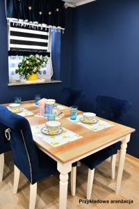 a dining room table with blue walls and blue chairs at Lemon & Jacuzzi in Boguszów-Gorce +13 photos