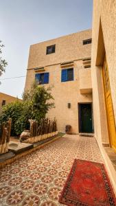 a building with a rug in front of a building at Thayri Hostel - Sea View in Sidi Kaouki