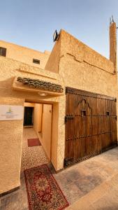 a building with a wooden gate and a door at Thayri Hostel - Sea View in Sidi Kaouki