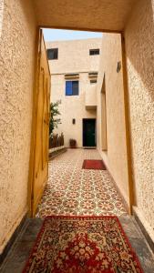 an alley with a rug on the floor and a building at Thayri Hostel - Sea View in Sidi Kaouki