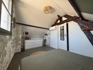 an attic bedroom with a bed and a window at La haute république in Brive-la-Gaillarde