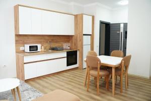 a kitchen and dining room with a table and chairs at Corner Apartments in Tirana