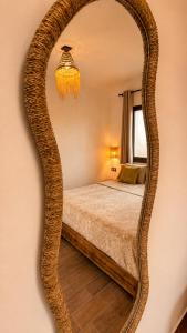 a bedroom with a large oval mirror on the wall at Thayri Hostel - Sea View in Sidi Kaouki