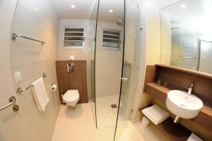
a bathroom with a toilet, sink, and shower at Hotel Koulnoue Village in Hienghène
