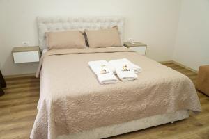 a bedroom with a bed with two towels on it at Corner Apartments in Tirana