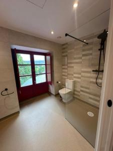ein Badezimmer mit Toilette und roter Tür in der Unterkunft Casa Cando in Castroverde + 90 Fotos