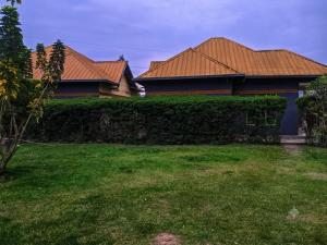 a house with a hedge in front of a yard at Amare Guest House in Cyuve