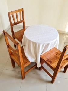 a table and two chairs with a white tablecloth and a table and chairsufficient at Amare Guest House in Cyuve