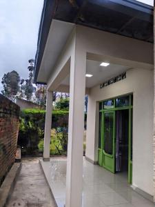 a building with a green door on the side at Amare Guest House in Cyuve