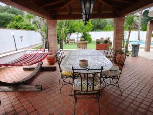 a patio with a table and chairs and a pool at La casetta di Daniela in Sabaudia