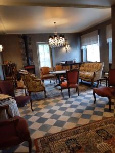 a living room with chairs and a table and a chandelier at la maison oubliée in Goetzenbruck