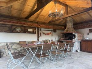 a kitchen with a table and chairs and a fireplace at Белите Къщи in Seltse