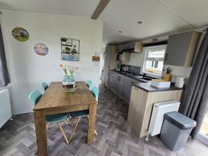 a kitchen and dining room with a table and chairs at PRACHTiG CHALET ZONNESTRAAL in Westerland