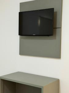a flat screen tv hanging on a wall at HOTEL ITAPUÃ vg in Várzea Grande