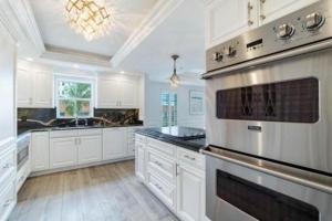 a large kitchen with white cabinets and an oven at Three Bedroom Gulffront Condo with Sunset Views in Naples +25 photos