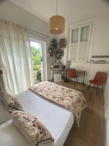 a bedroom with a bed and a table and a window at Les Charmettes chambre double indépendante in Villemoisson-sur-Orge