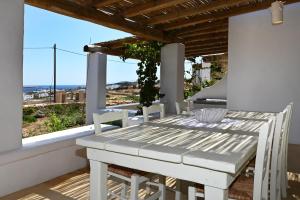 a white table and chairs on a balcony with a view at Pambelos Lodge - Apartments in Koufonisia