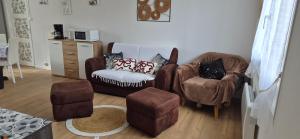 a living room with two chairs and a stool at Ma petite maison in Vierzon