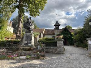 a statue of a woman in front of a church at La Vieille Demeure in Barbizon