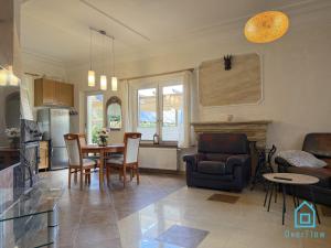 a kitchen and living room with a table and chairs at NaWypasie Grand Apartment with Fireplace Beautiful Garden SUP Board and Just 30 Minutes from Gdańsk and Gdynia in Szemud