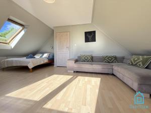 a living room with a couch and a window at NaWypasie Grand Apartment with Fireplace Beautiful Garden SUP Board and Just 30 Minutes from Gdańsk and Gdynia in Szemud