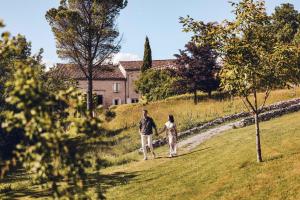 a man and a woman walking down a field at LES 2 CABANES in Labastide-Gabausse