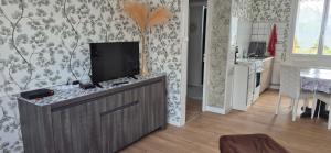 a kitchen with a flat screen tv on a cabinet at Ma petite maison in Vierzon