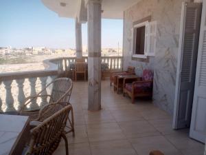 a balcony with chairs and a view of the desert at Zaytouna camp Room 2 in Marsa Matruh