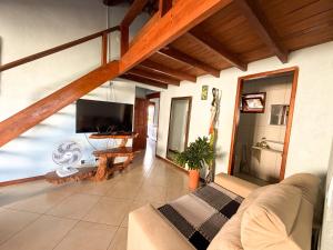 a living room with a couch and a flat screen tv at Casa Magna in Itacaré