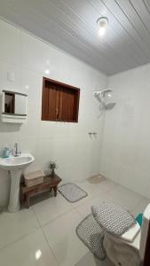 a white bathroom with a sink and a toilet at Alto do Paraíso Bichinho in Prados