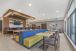a restaurant with tables and chairs and a bar at Best Western Plus Marquette Hotel & Suites in Marquette