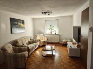 ein Wohnzimmer mit zwei Sofas und einem Tisch in der Unterkunft Bel - Self Check-Inn in Eggenfelden