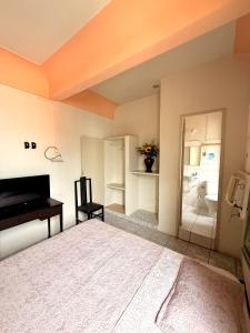 a bedroom with a bed and a piano and a bathroom at Hotel Central in Recife