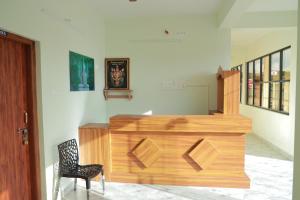 a room with a wooden counter and a chair at Vetri Residency in Agastīswaram