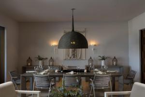 a dining room with a table and chairs and a chandelier at Porta Fortuna Villa Punta Mita Gates in Punta Mita