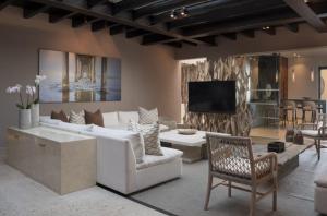a living room with a white couch and a tv at Porta Fortuna Villa Punta Mita Gates in Punta Mita