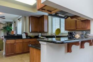 a large kitchen with wooden cabinets and black counter tops at Three Bedroom Corner Condo with Gulf View Balcony in Pensacola