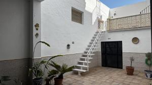 a white ladder on the side of a building at Patio de Los Barberos 3 in Valle de Abdalagís +4 photos